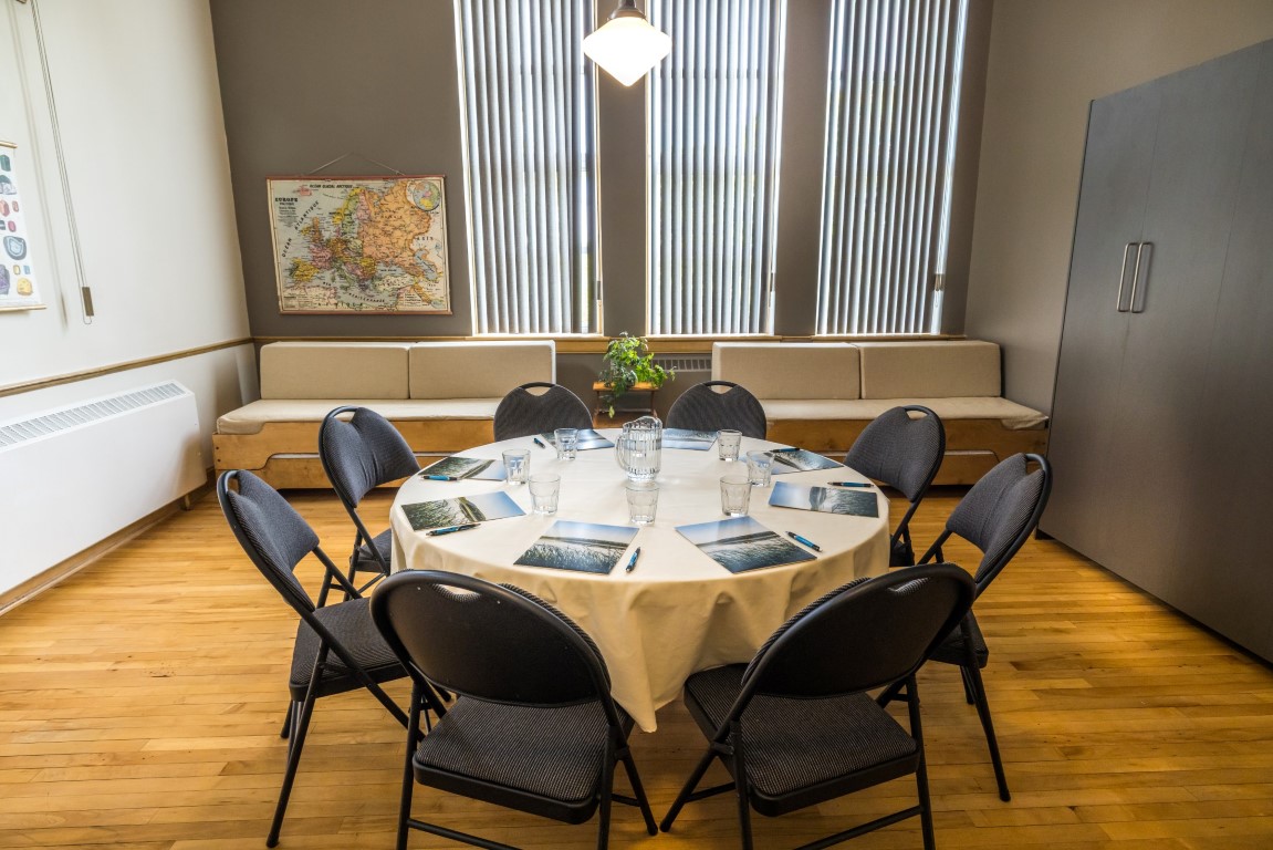 Table ronde avec banquettes et décor patrimonial, aménagée pour une retraite stratégique en petit comité à l'Espace du Carmel