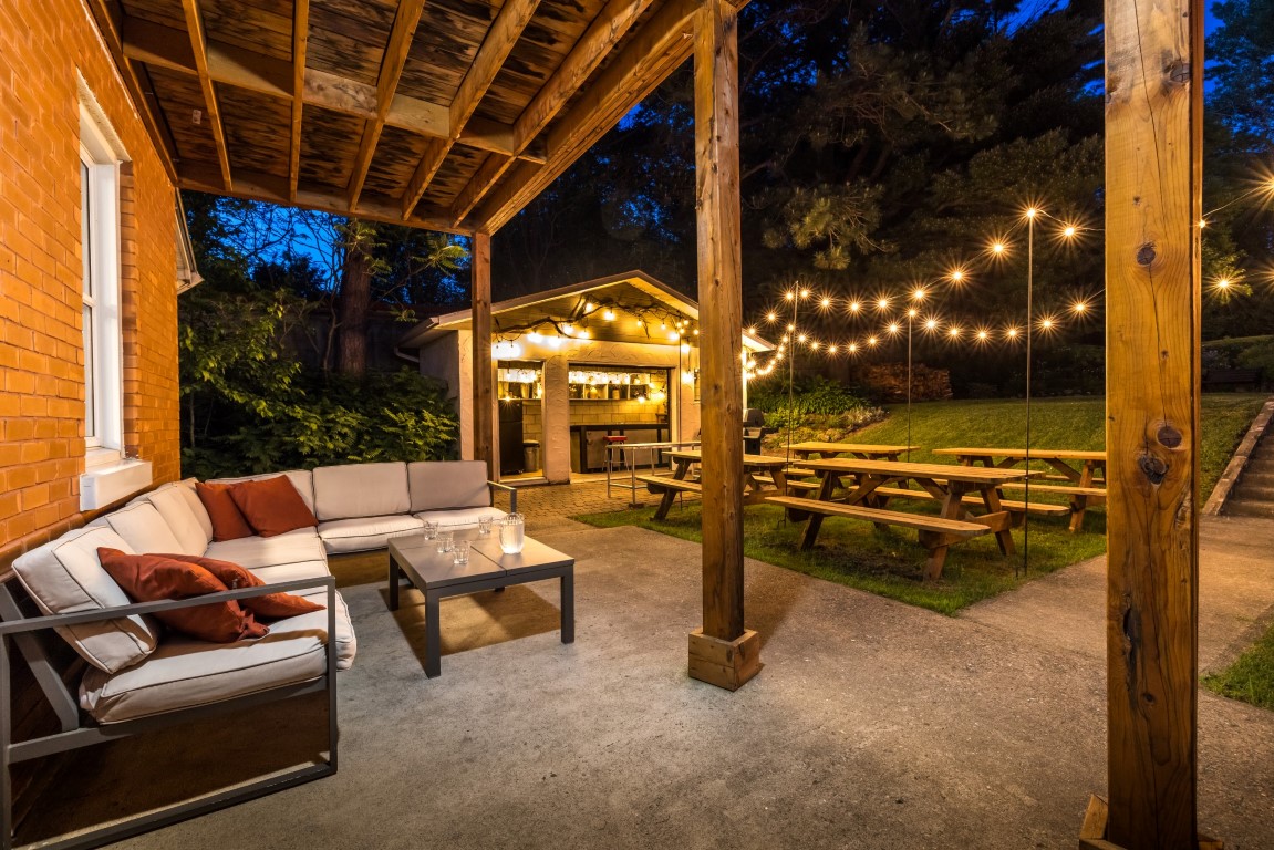 Terrasse extérieure éclairée en soirée avec mobilier lounge, propice à la détente pendant une retraite stratégique à l'Espace du Carmel