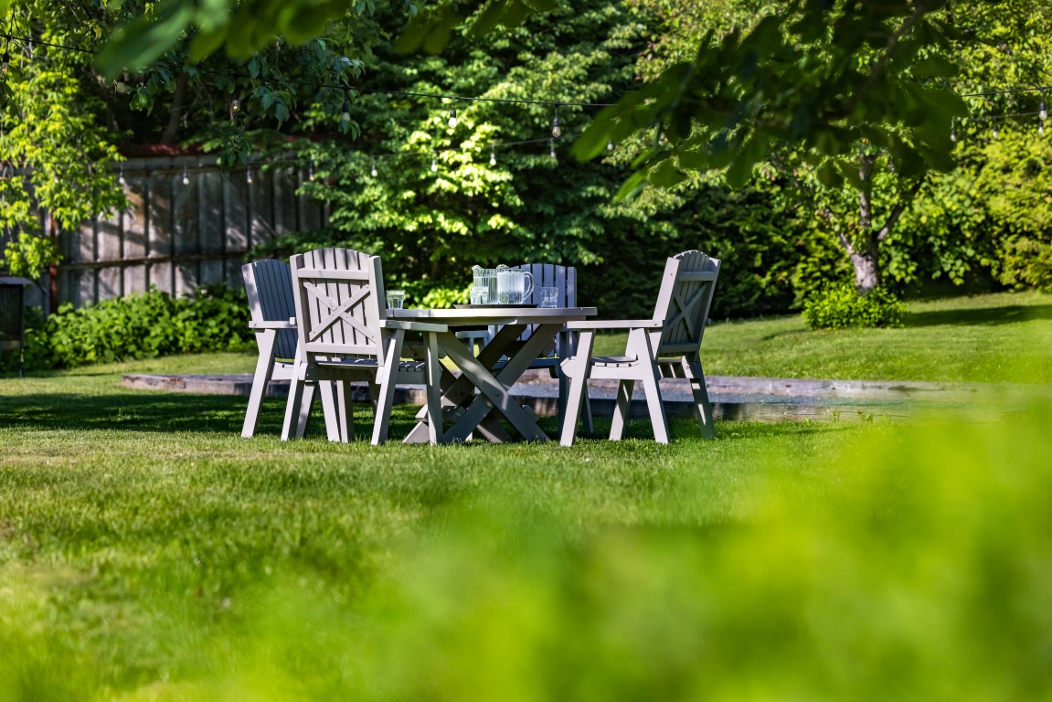 Mobilier de jardin sur le gazon avec guirlandes lumineuses, propice aux activités de groupe à l'Espace du Carmel