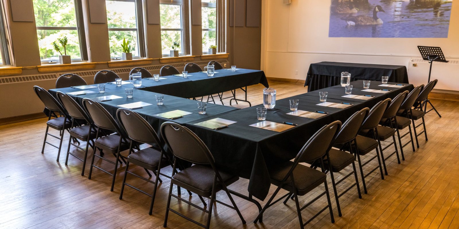 Salle spacieuse aménagée en configuration U avec grandes fenêtres et éclairage chaleureux à l'Espace du Carmel